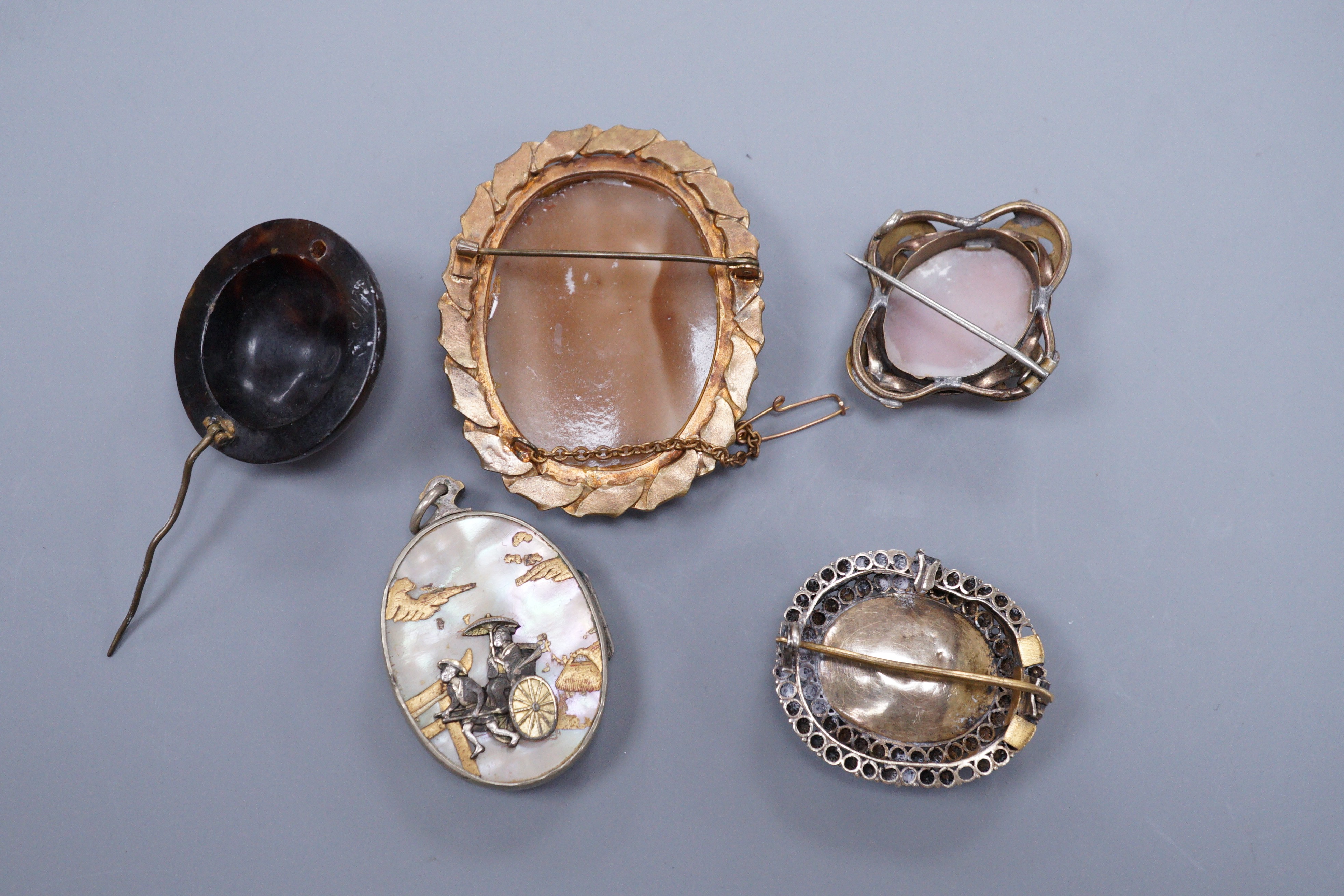 A Victorian gold pique circular brooch, 3cm (a.f.), two cameo brooches, a gilt metal brooch and a Japanese mother of pearl locket